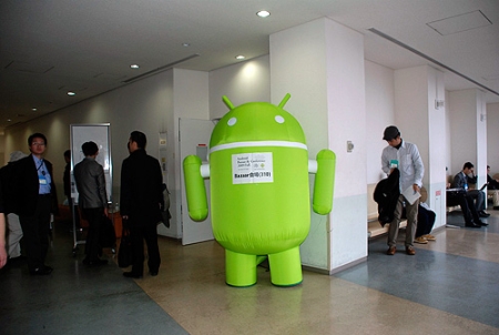 　11月30日に開催された、日本アンドロイドの会が主催するイベント「Android Bazaar and Conference 2009 Fall」のバザール（展示）会場では、Android機器向けのハードウェアやアプリケーションを制作した企業がそれぞれの製品を披露していた。その様子を写真で紹介する。

　こちらはバザール会場の入り口に仁王立ちする「アンドロイド君」。モーターで送り込まれた空気で自立している。