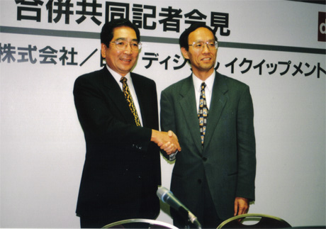 　1998年、米Compaq Computerと米Digital Equipment Corporation（DEC）の合併にあわせて、日本でも、コンパックコンピュータと日本DECの合併が両社社長から発表された。写真はそのときのもの。左は、コンパックコンピュータ社長の高柳肇氏。コンパックに買収された日本タンデム・コンピューターズの社長から就任。その後、Hewlett-PackardによるCompaq買収においても、買収された側にも関わらず、新生日本ヒューレット・パッカードの社長に就任した。一方、右は日本DEC社長の上田寿男氏。1998年3月に社長就任した際には、すでに1月にCompaqによるDEC買収が発表されたあと。自ら日本DEC最後の社長ということを知っていながらの就任だった。上田氏は新生コンパックで副社長に就任したあと、日本NCR社長に転身した。（画像をクリックすると、次のページへ進みます）