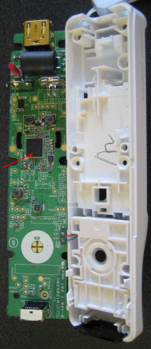 　基盤にある最大のチップは、赤い矢印で示しているBroadcom製のBluetoothコントローラチップだった。ヌンチャクを接続するコネクタのすぐ近くには大型のコンデンサが配置されている。これはヌンチャクが接続された際に大きな電力が流れるためだろう。プラスチックカバーに書き込まれているサインは、品質保証マークか何かだと思われる。