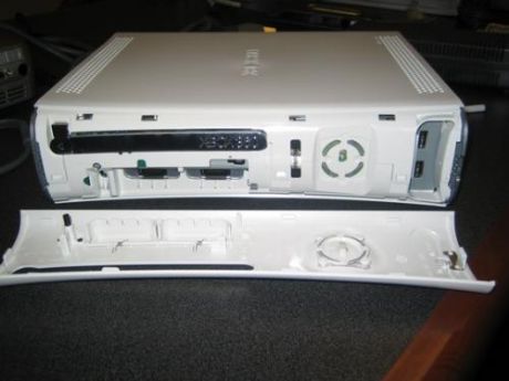 　Xbox 360本体の分解の第1段階は、フェイスプレートの取り外しだ。フェイスプレートの左右（ユニットを縦置きしている場合は上下）を押さえてからそっと前に引っ張る。親指をUSB端子の部分に置くとよい。わずかな力でフェイスプレートが外れるはずだ。