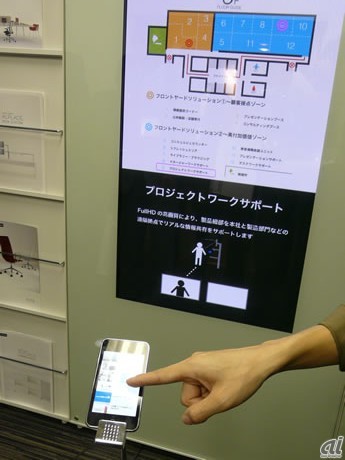 　UCHIDA FAIR 2010 in 東京のメインフロアとなる9階に展示されたデジタルサイネージとiPod touchとの連動提案。展示会場などで自分がいる場所の確認や目的の場所を探すために活用することも可能。iPod touchにアプリをダウンロードして使用する。