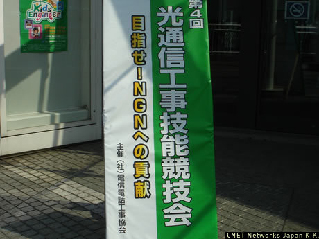 北京ではオリンピック、甲子園では高校野球と、連日熱戦が繰り広げられているが、7月29日には、パシフィコ横浜において、デジタル情報化社会のインフラ構築を支える人々が、その工事技能日本一の座をかけた戦いに挑んだ。その名も「光通信工事技能競技会」。社団法人電信電話工事協会の主催により今年で4回目を数えるこの大会は、情報通信工事にかかわる技術者の施工技術の向上や業界全体の工事能力の向上を目的にしたもの。普段何気なく利用しているインターネットだが、そこで流れるデータ（コンテンツ）を「血液」とするなら、この競技会はいわば血液を体中に巡らせるための「血管」を作るための技能を競うものといえる。