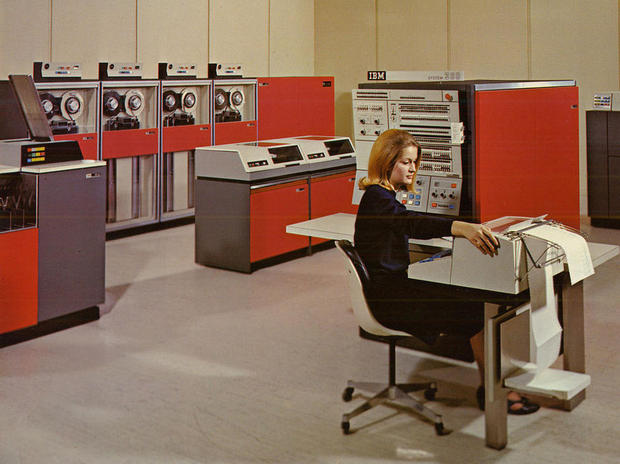 　S/360の設計の多くは、当時存在していたコンピュータの100倍の速度で動作する製品を生み出そうとするIBMの1956年のプロジェクトに端を発している。

　IBMは、当時の新発明であるトランジスタを使用した「IBM 7030」というコンピュータをロスアラモス国立研究所向けに開発した。

　このマシンはパフォーマンス目標の達成にこそ至らなかったものの、現在のプロセッサ設計の中核でいまだ息づいている、アーキテクチャ上のさまざまな特徴の土台となった。このマシンは複数の命令を同時に読み取って解釈し、計算結果を予測し、最適な予測結果に従ってコードの投機的実行を行い、内部リソースの有効利用を推し進めるために未実行命令の先読みをすることもできた。

　写真は「System/360 model 40」を操作する女性。