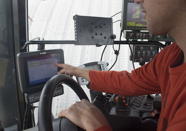 「iPad」による更新データの提供

　Jones家の主要な機材小屋に格納されているトラクタのタイヤの上に置かれた「iPad」。iPadは農機具の運転席内でモニタとして使用される。