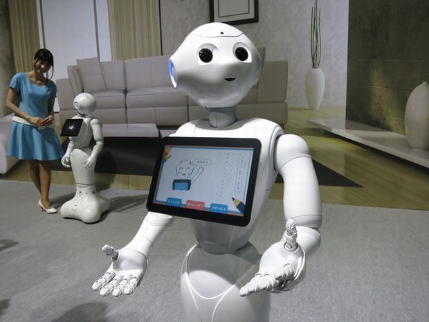 Aldebaranが開発した、感情を読み取るロボット「Pepper」が両手を差し伸べている。
