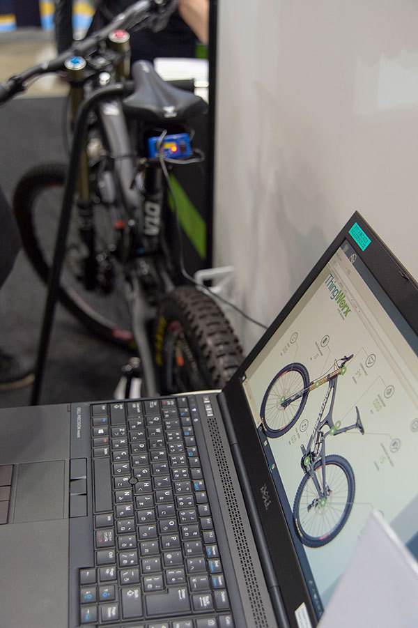 IoTセンサー搭載自転車のデモ。写真奥にある自転車を操作するとセンサーからの情報がシステムに伝わり、画面上の数値が変わっていく