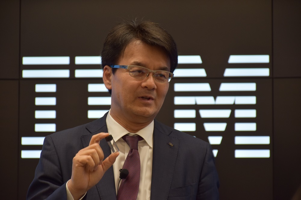 日本IBMの山口氏。先進的なテクノロジーの例として、極小のCPUを紹介している