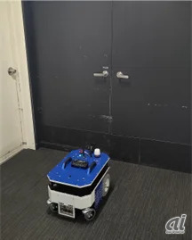 ロボットが点検対象のドアに正対して写真撮影している様子