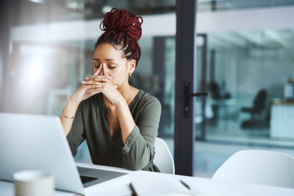 疲れた様子でノートPCに向かう女性