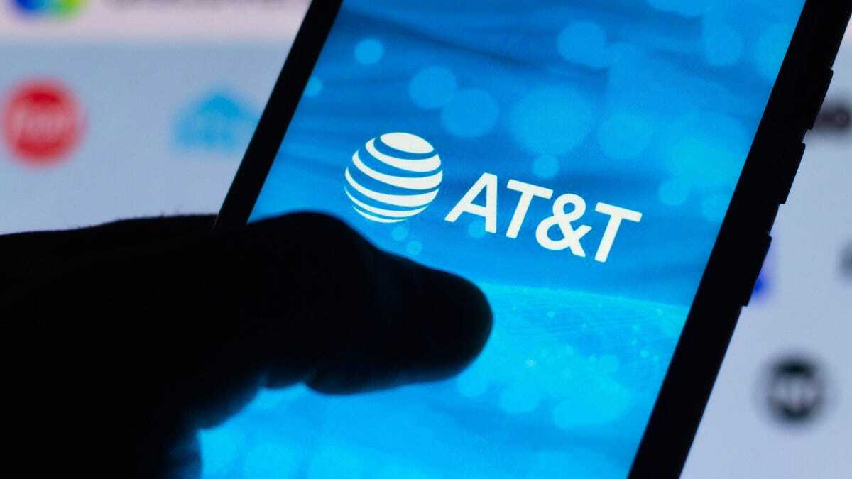 AT&Tのロゴを表示したスマホを持つ手