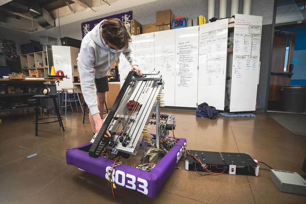 チームのロボット「Paddo」
このロボットは、カリフォルニア州北部の高校生ロボットマニアが集まるチームであるHighlander Roboticsが構想、製作したものだ。ロボットの名前である「Paddo the Frog」は、ドイツの童話「カエルの王子様」のスコットランド版のタイトルにちなんでいる。

この2019年に設立された学生主導のチームは、「FRC 8033」という別名を持っており、世界中から集まった数千のチームの1つとして、今回のFIRST Robotics Competitionに出場する。今大会のテーマは「Chagrged Up」だ。 

大会では、3300以上のチームが、国連が掲げるSDGsの7番目の目標である、「すべての人々に、安価かつ信頼できる持続可能な近代的なエネルギーへのアクセスを確保する」ことに関連した課題をクリアできるロボットの構想、設計、製作に挑んでいる。 

この写真では、チームメンバーの1人であるCaetano de Figueiredo君が、ロボットの伸縮クレーンブームの駆動系を調整している。背後にあるホワイトボードを見れば分かるように、競技ロボットを製作するには、長い時間をかけて立案した綿密な計画が必要だ。FRC 8033の高校生イノベーターたちは、20人の経験豊富なメンターから指導を受けながら、チームの本拠地であるサンフランシスコ東部のピードモンド高校の工房で、週末や学校の休みに長時間活動している。時には1回に12時間以上作業することもあるという。